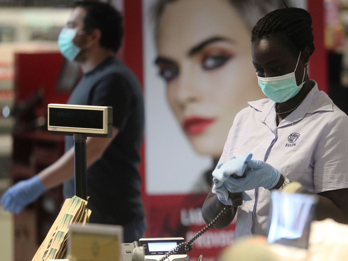 Foto: Una empleada usa mascarilla en un establecimiento de Madridn (EFE)