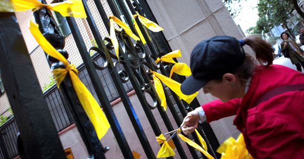 Foto: Ciudadanos contrarios a la independencia retiran lazos amarrillos en Barcelona. (EFE)