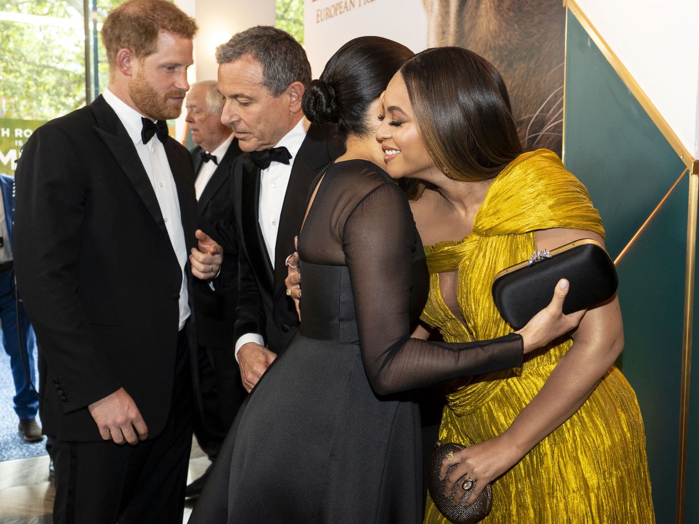 El príncipe Harry, hablando con el productor de Disney, Bob Iger, mientras Meghan abraza a Beyoncé. (Reuters) 