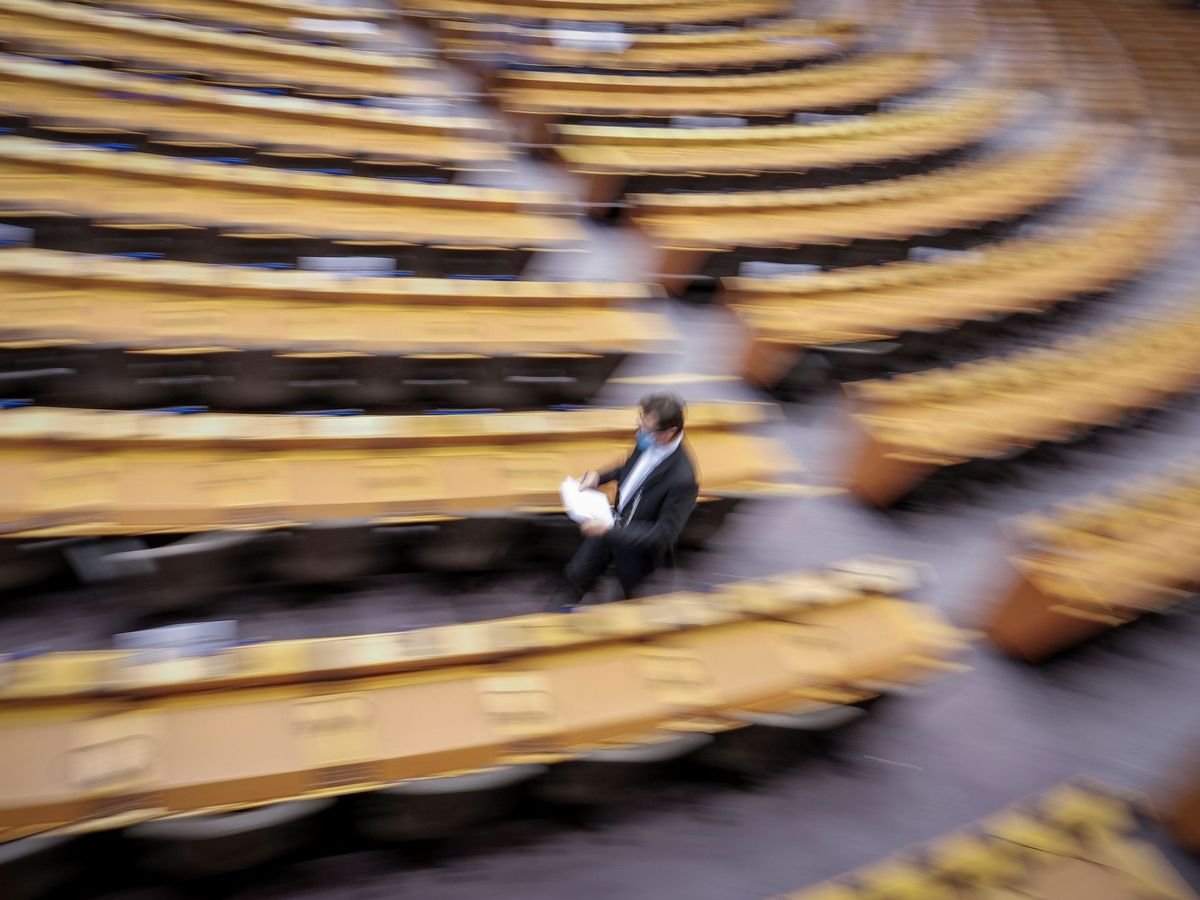 Foto: Un funcionario camina entre los escaños del Parlamento Europeo. (EFE)