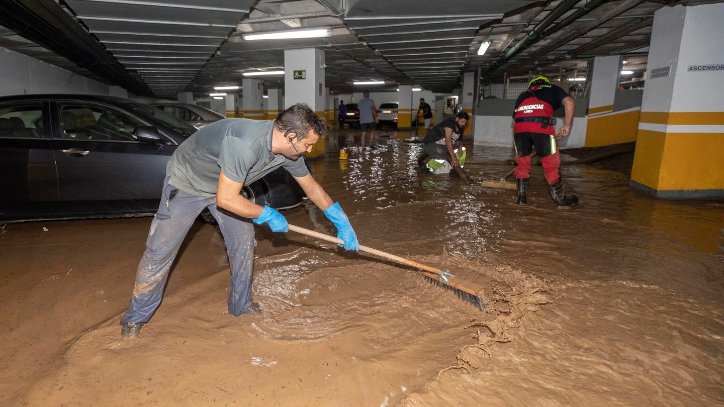 Trabajadores del Ayuntamiento de Águilas achican agua del garaje de un hotel, tras la gota fría de este jueves. (EFE)