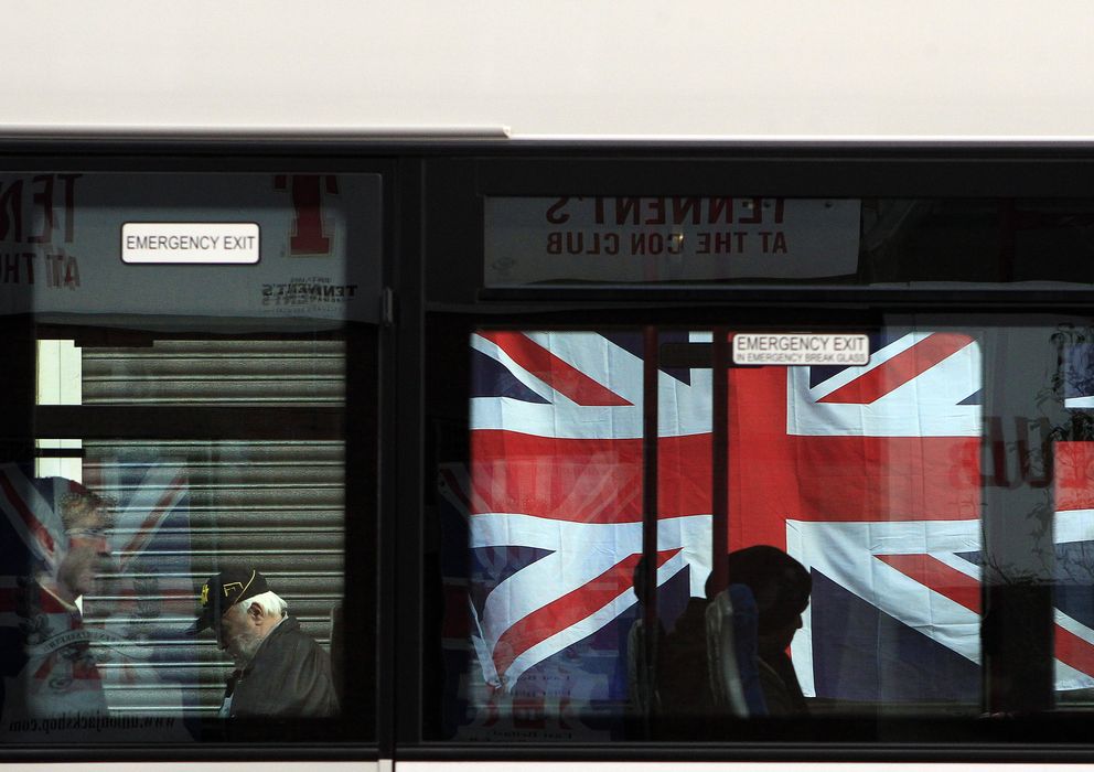 Foto: Un autobús pasa ante una bandera del Reino Unido colgada de un edificio (Reuters).
