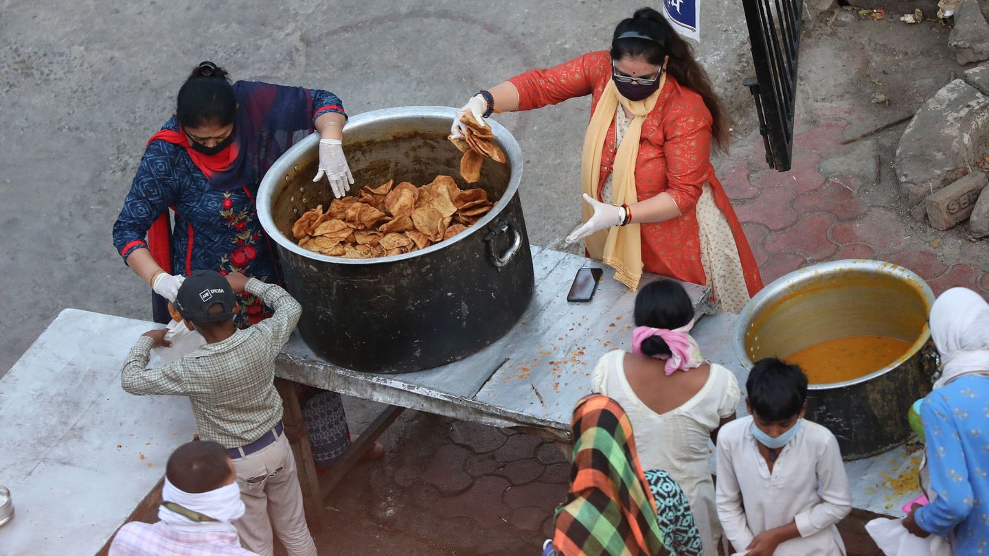 Dos mujeres reparten comida en India. (Reuters)