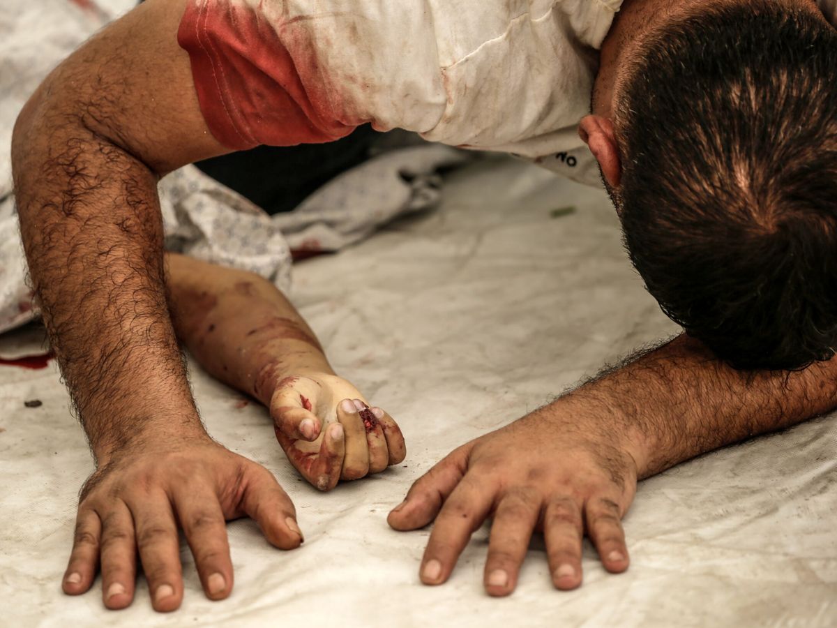 Foto: Un palestino llora sobre el cuerpo de su sobrino muerto en un bombardeo israelí. (EFE/Mohammed Saber)