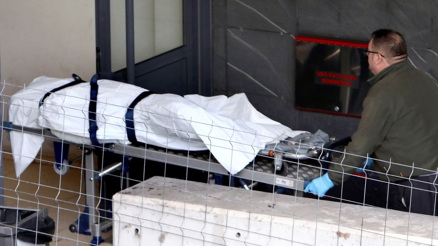 Operarios de la funeraria trasladan al policlínico de Conxo en Santiago de Compostela el cuerpo. (EFE)