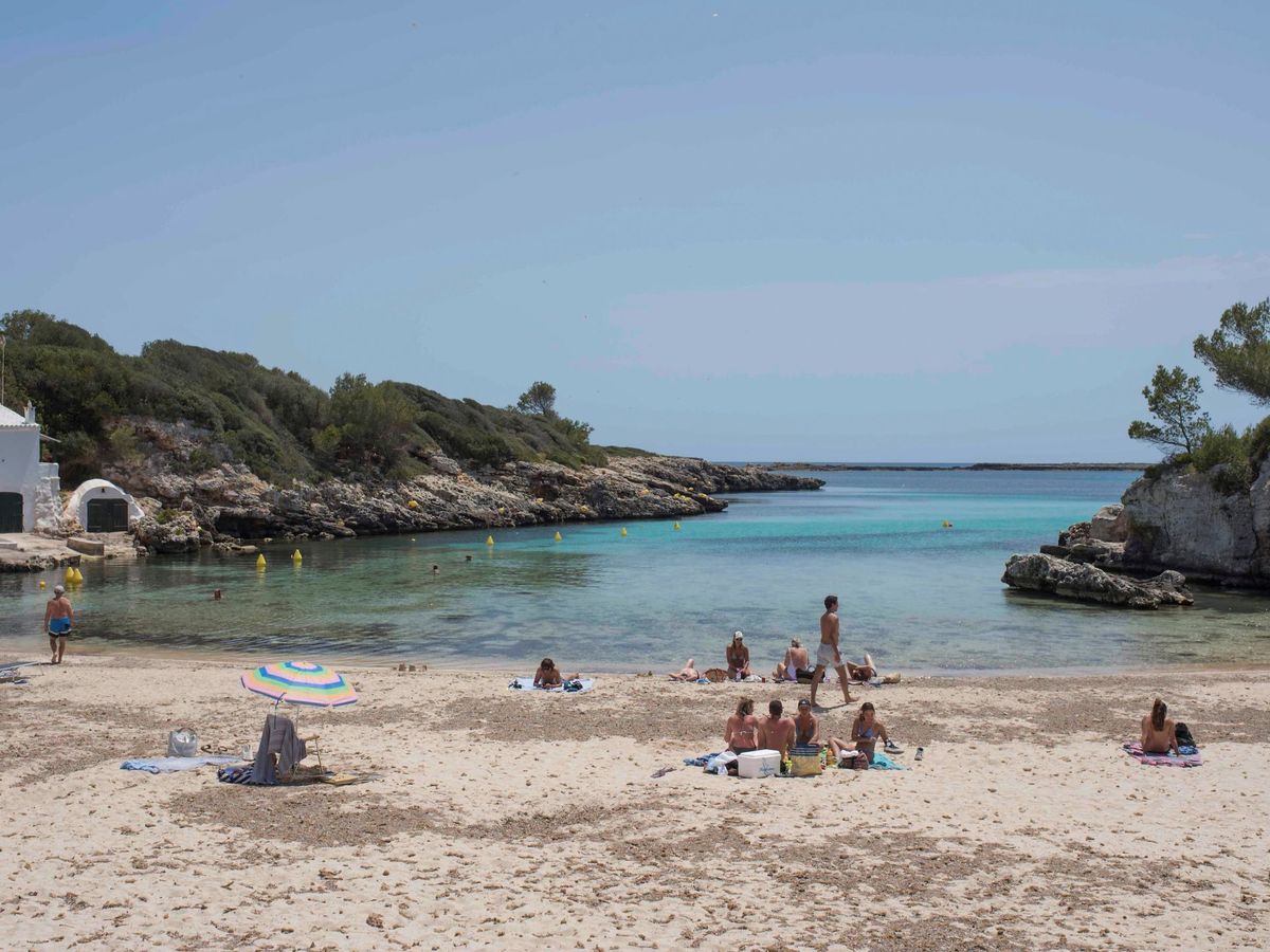 Foto:  Turistas toman el sol en la playa de Binisafúller, en Menorca. (EFE) 