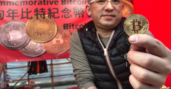 Foto: Un vendedor muestra una moneda con el logotiopo de Bitcoin en Hong Kong.