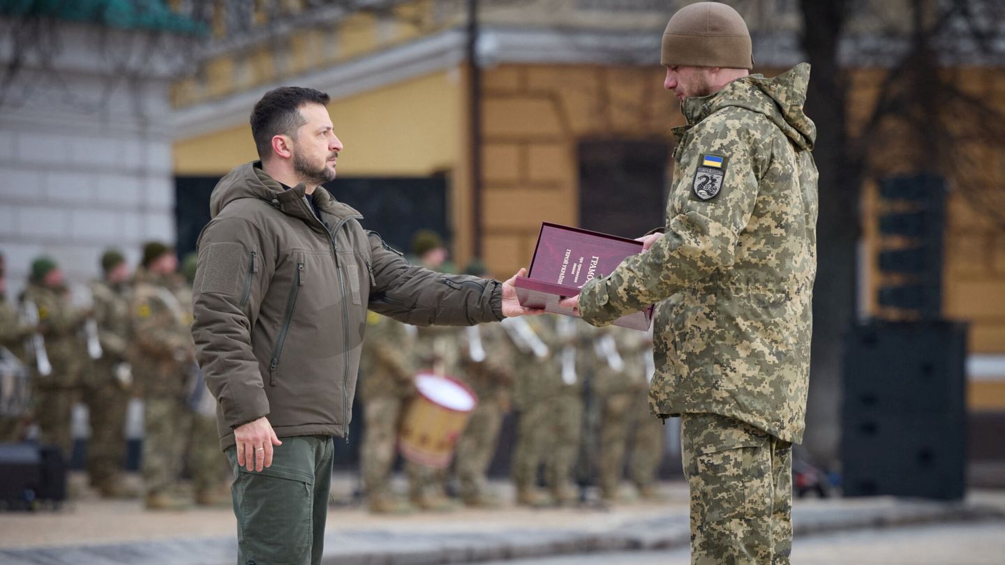 Ukraine's President Volodymyr Zelenskiy handovers a flag to a serviceman during a ceremony dedicated to the first anniversary of the Russian invasion of Ukraine, amid Russia's attack on Ukraine, in Kyiv, Ukraine February 24, 2023. Ukrainian Presidential Press Service Handout via REUTERS ATTENTION EDITORS - THIS IMAGE HAS BEEN SUPPLIED BY A THIRD PARTY.