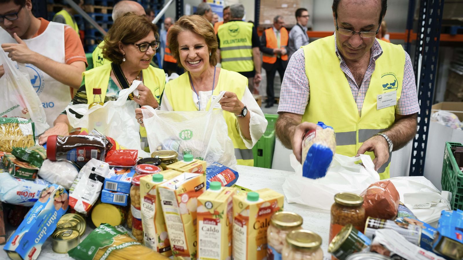 Foto: Voluntarios empaquetan alimentos en las instalaciones del banco de alimentos de Alcalá de Henares. (EFE)