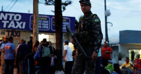 Foto: Un soldado patrulla una calle llena de inmigrantes venezolanos que acaban de cruzar el puesto fronterizo de Pacaraima, Brasil, el 19 de agosto de 2018. (Reuters)