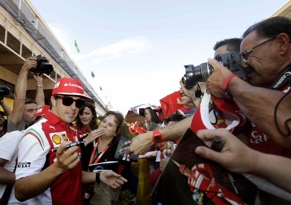 Foto: Fernando Alonso firma autógrafos en el pit lane en el Circuito de Catalunya. (EFE)