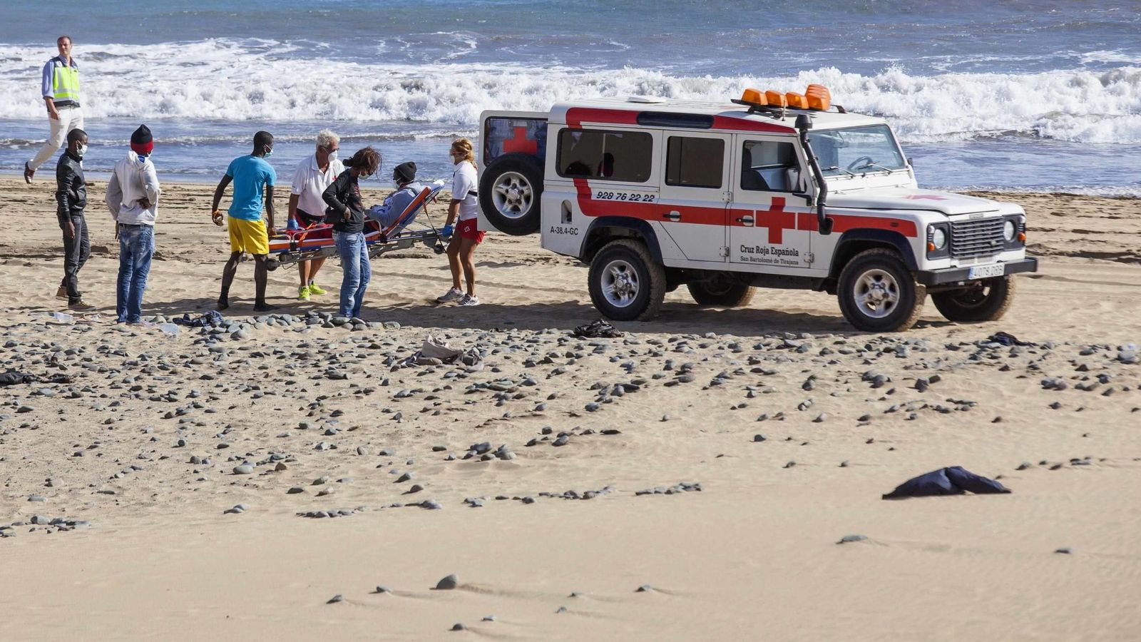 Foto: Miembros de la Cruz Roja llevan a un inmigrante a un vehículo en la playa de Maspalomas, en Gran Canaria. (Reuters)