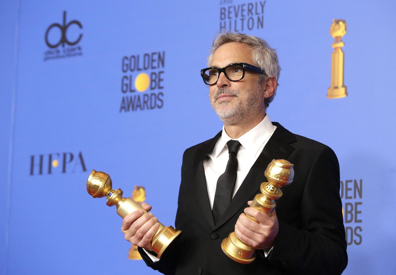 Alfonso Cuarón con sus dos globos de oro. (Efe)