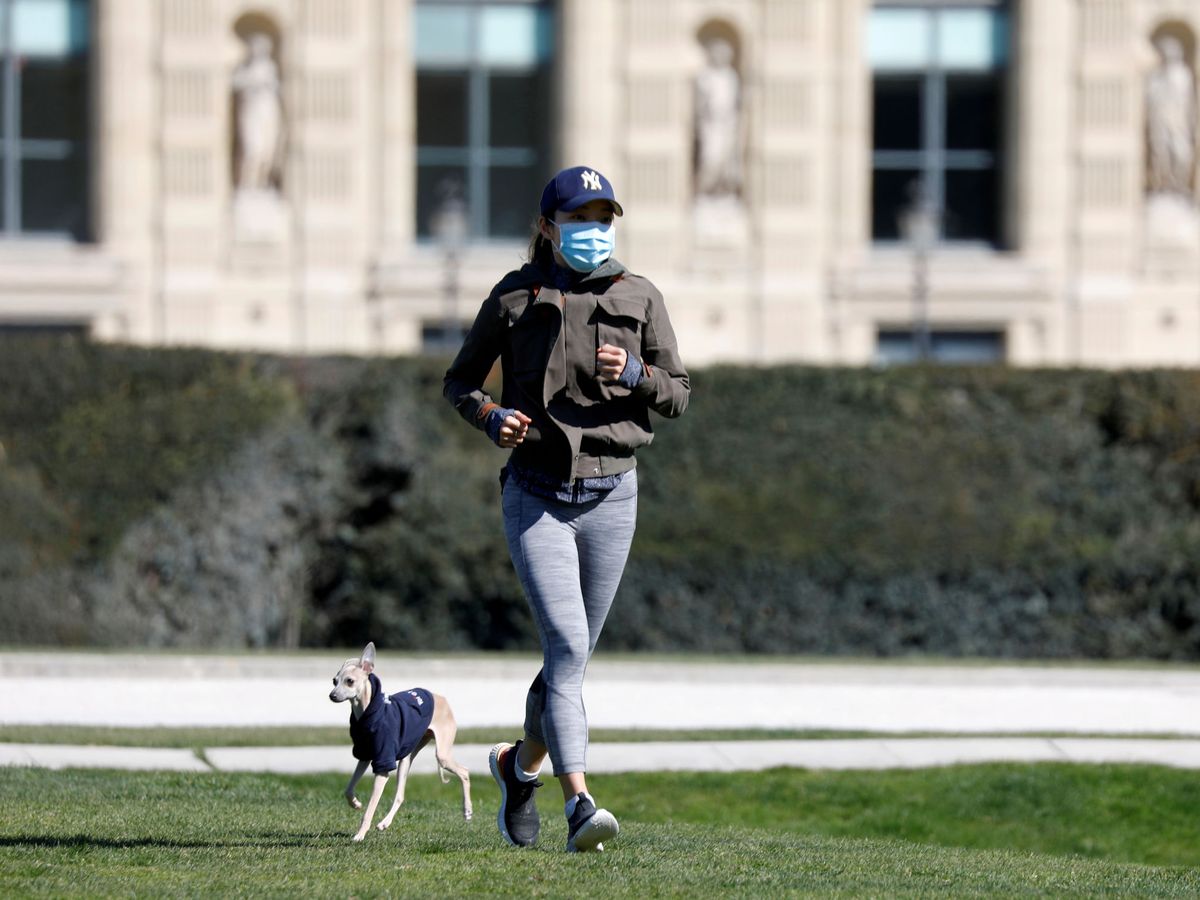 Foto: Una mujer hace ejercicio junto a su perro en el Jardín de las Tullerías, en París. (Reuters)