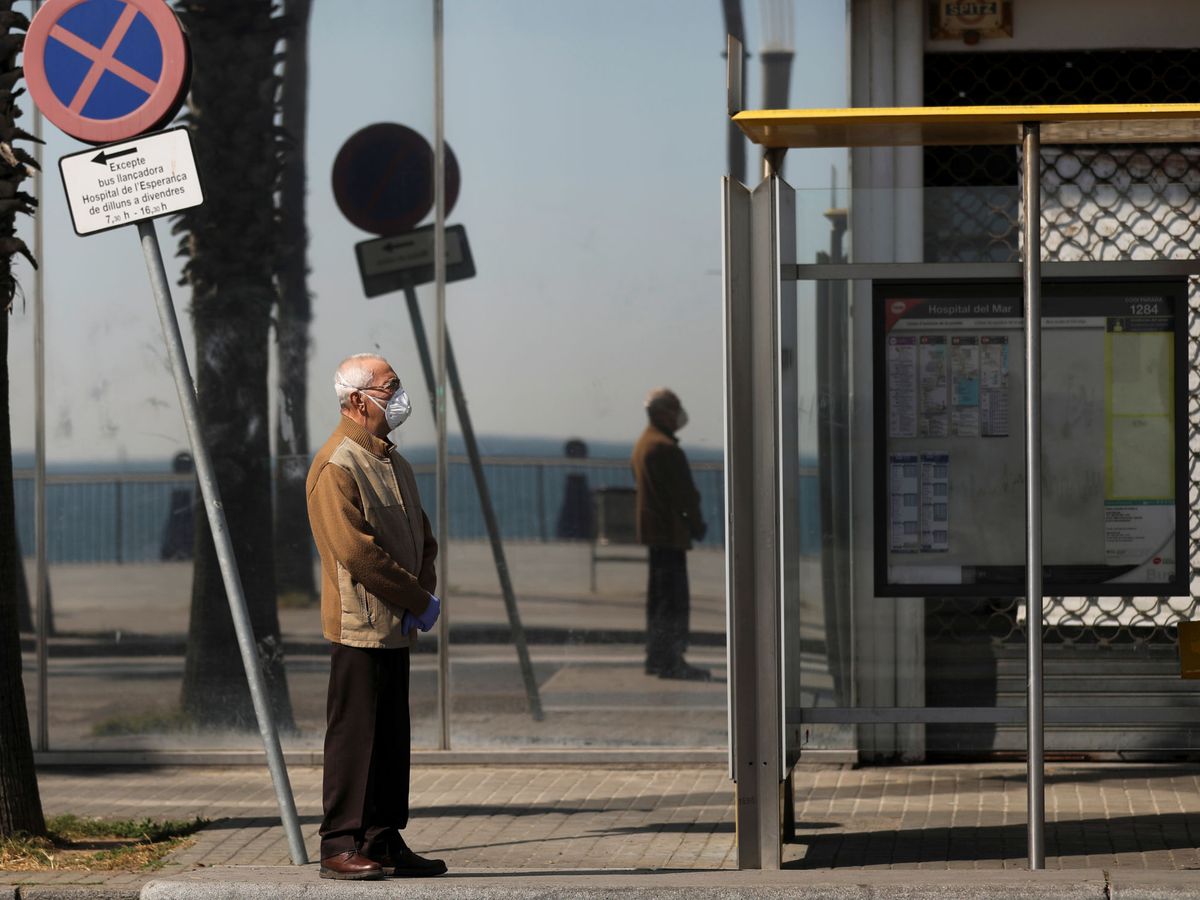 Foto: Un hombre, con mascarilla, espera al autobús. (Reuters/Nacho Doce)