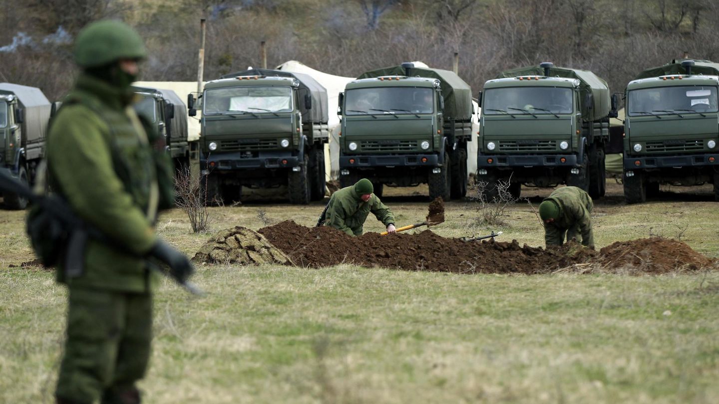 Soldados rusos sin distintivos cavan trincheras en Perevalnoye, cerca de una base ucraniana (Reuters).