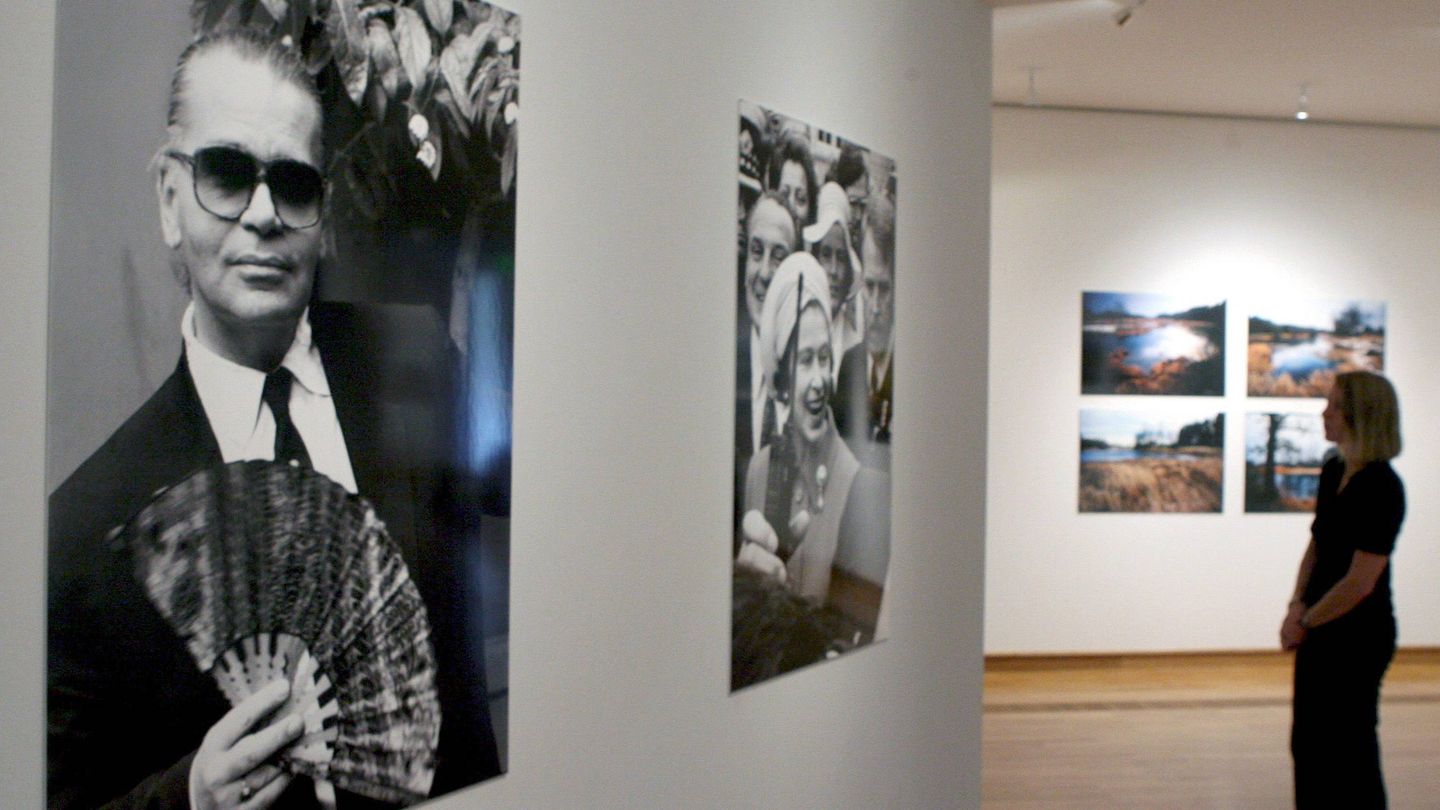 Una mujer mira dos imágenes del fotógrafo Lothar-Günther Buchheim que muestran al diseñador Karl Lagerfeld. (EFE)