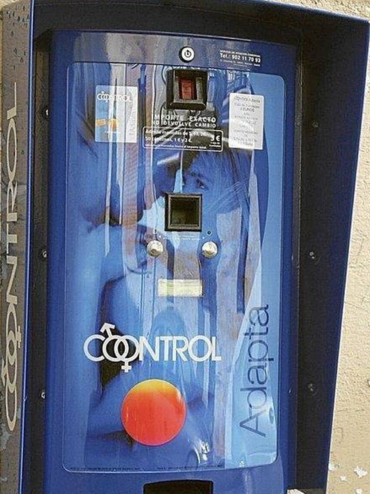 Máquina de venta de preservativos colgada de la fachada de una farmacia. (EC)