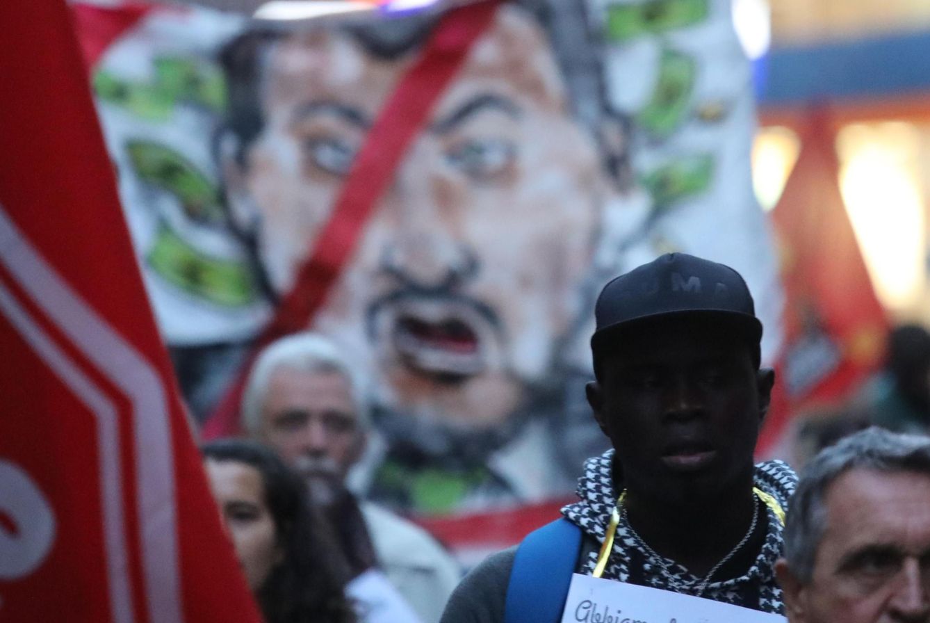 Protesta en Calabria contra la detención del alcalde pro-inmigración de Riace, con una imagen de Salvini al fono (EFE)