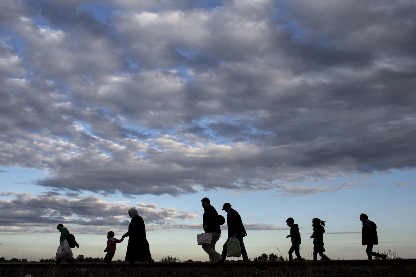 Refugiados sirios caminan por una vía de tren hacia un centro de internamiento en Roszke, Hungría. (Reuters)