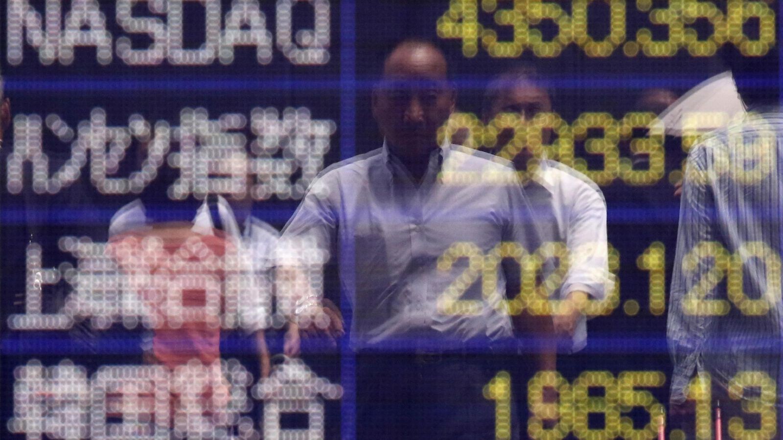 Foto: Reflejo de un hombre frente a un panel con varios índices. (Reuters)