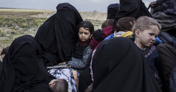 Foto: Mujeres con sus hijos llegan al campo de desplazados huyendo de los combates en Baghuz, último bastión del Estado Islámico en Siria. (J.M. López)