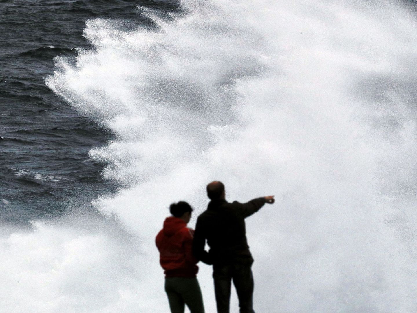 Un grupo de turistas obverva las olas en Muxía, A Coruña, la pasada semana. (EFE)
