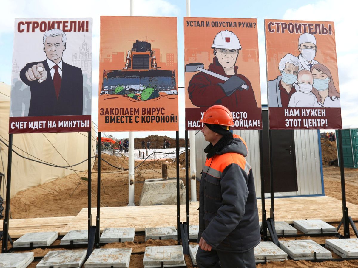 Foto: Un obrero, junto a carteles de propaganda rusos contra el coronavirus, en Moscú. (Reuters)