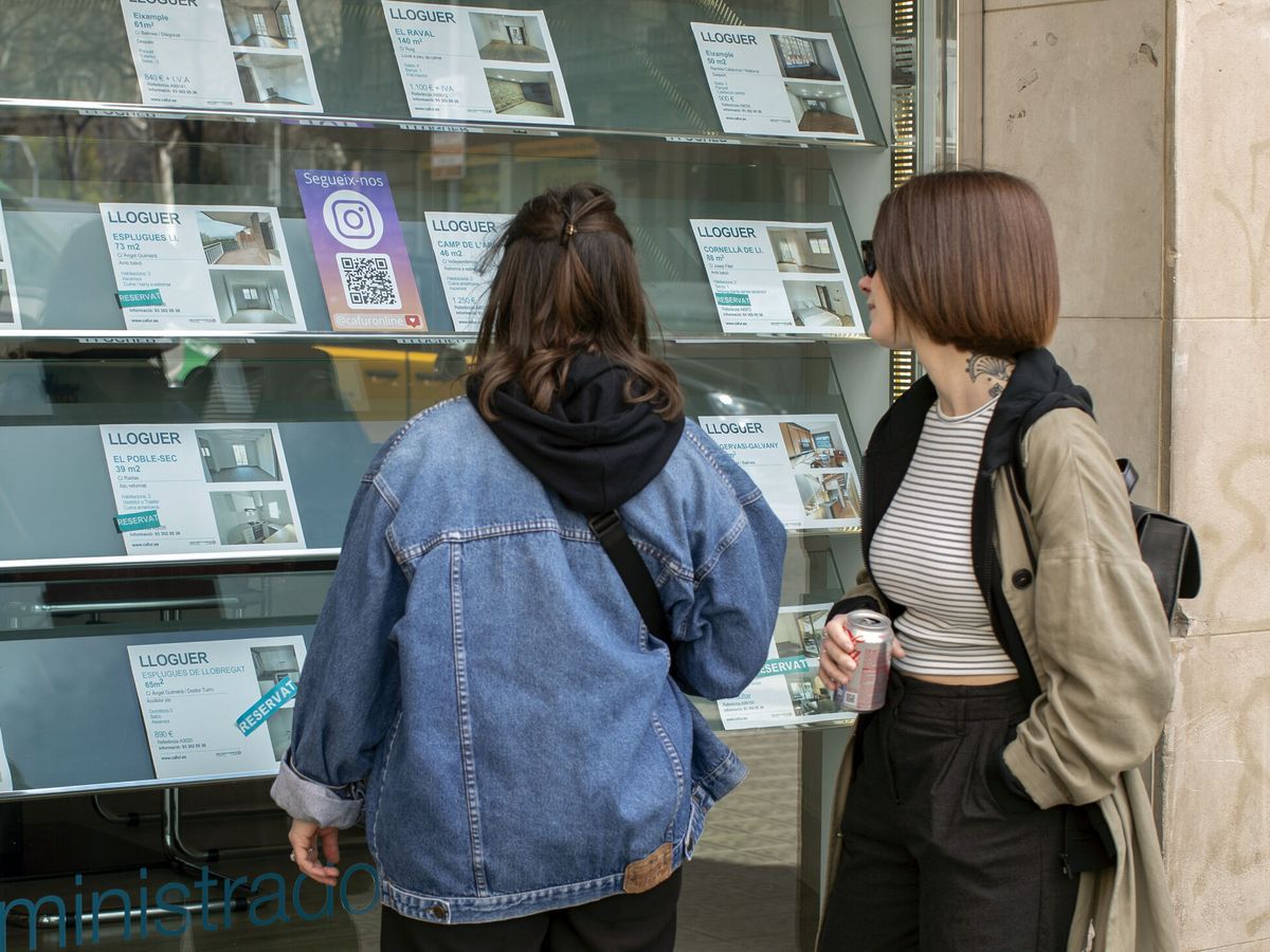 Foto: Dos jóvenes miran los anuncios de una oficina inmobiliaria. (EFE/Marta Pérez)