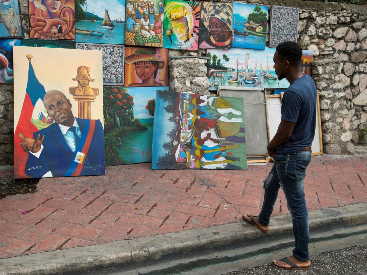 Foto: El artista Samuel Saint Louis sostiene una pintura del presidente Jovenel Moïse. (EFE)