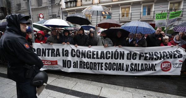 Foto: Centenares de jubilados exigen bajo la lluvia una subida digna de su pensión. (EFE)