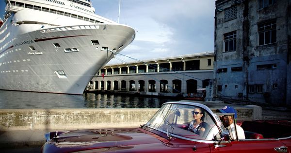 Foto: Dos turistas conducen un coche frente al puerto de La Habana, capital de Cuba. (Reuters)