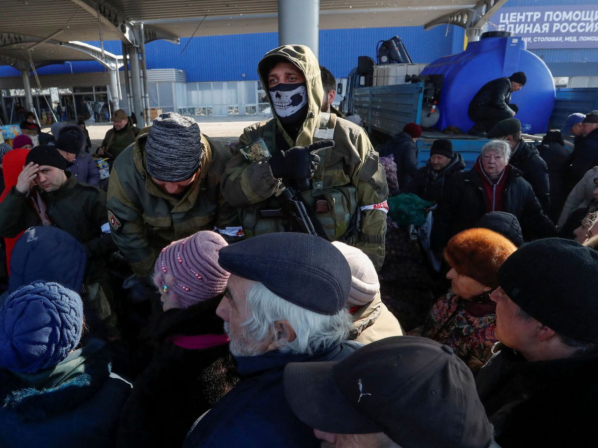 Foto: Soldados rusos vigilan a la población de Mariúpol haciendo cola para recibir ayuda. (Reuters/Alexander Ermochenko)