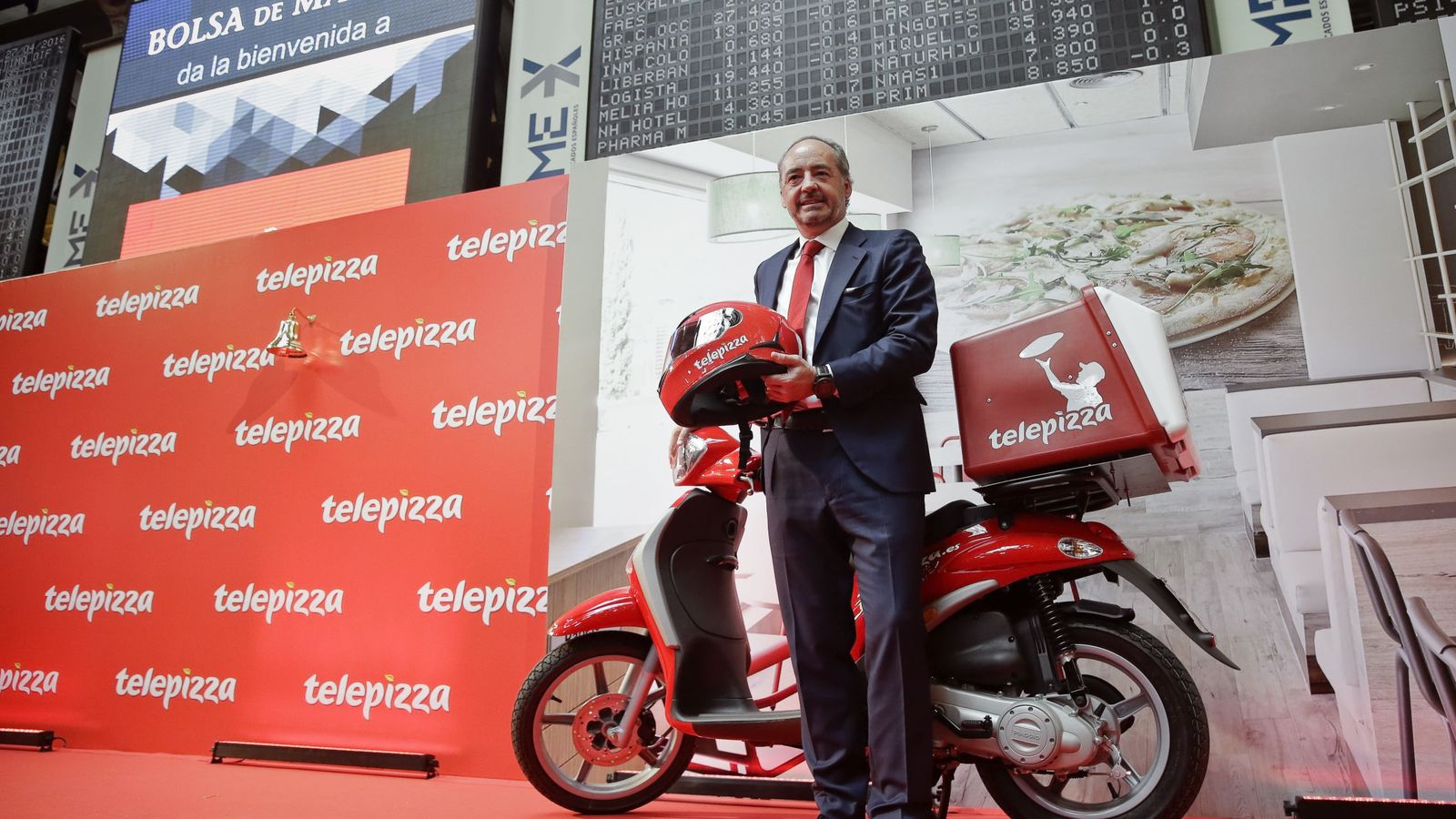 Foto: El presidente de Telepizza, Pablo Juantegui, posa en el parqué madrileño junto a una de las típicas motos de reparto. (EFE)