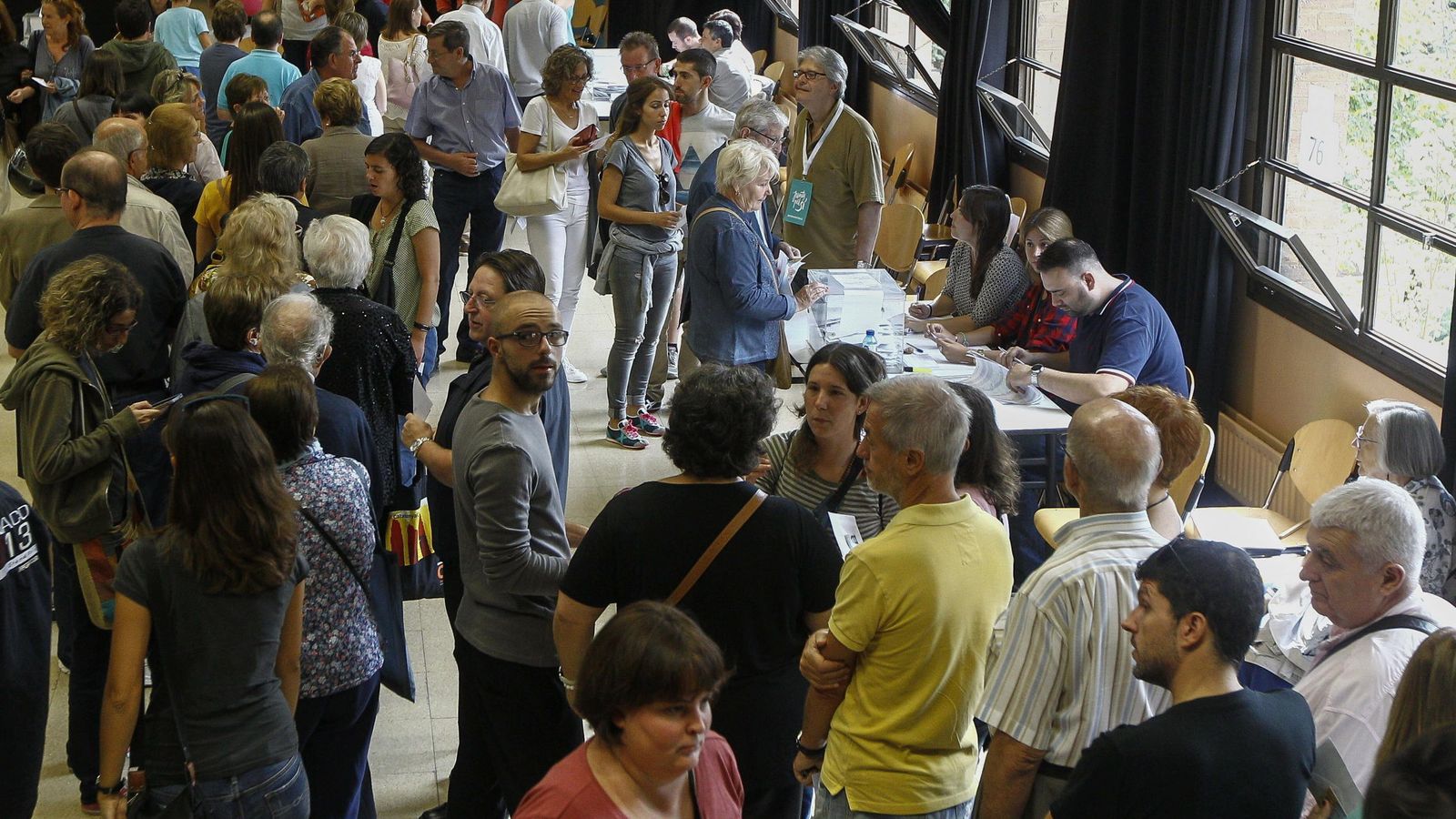 Foto:  Colas de ciudadanos esperan su turno para votar en un colegio electoral de Barcelona. (EFE)