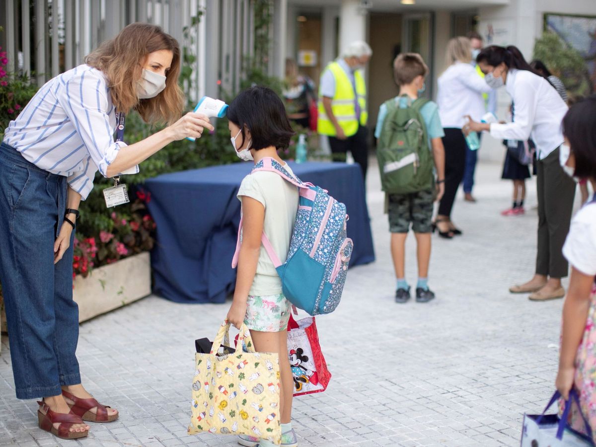 Foto: Una trabajadora toma la temperatura a una niña a la entrada del colegio privado internacional American School of Barcelona. (EFE)