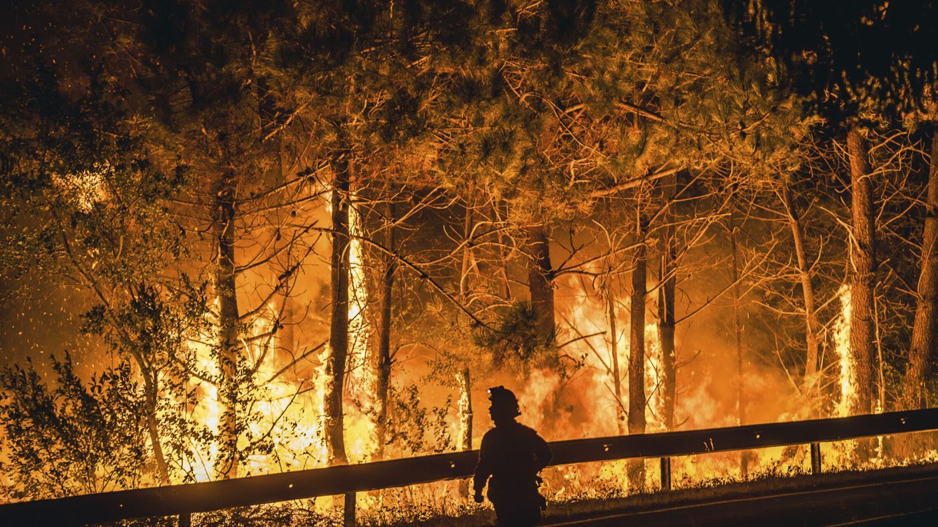 Foto: Un operario de las BRIF lucha contra las llamas en la madrugada de este sábado para extinguir el incendio en Boiro. (EFE/Óscar Corral)
