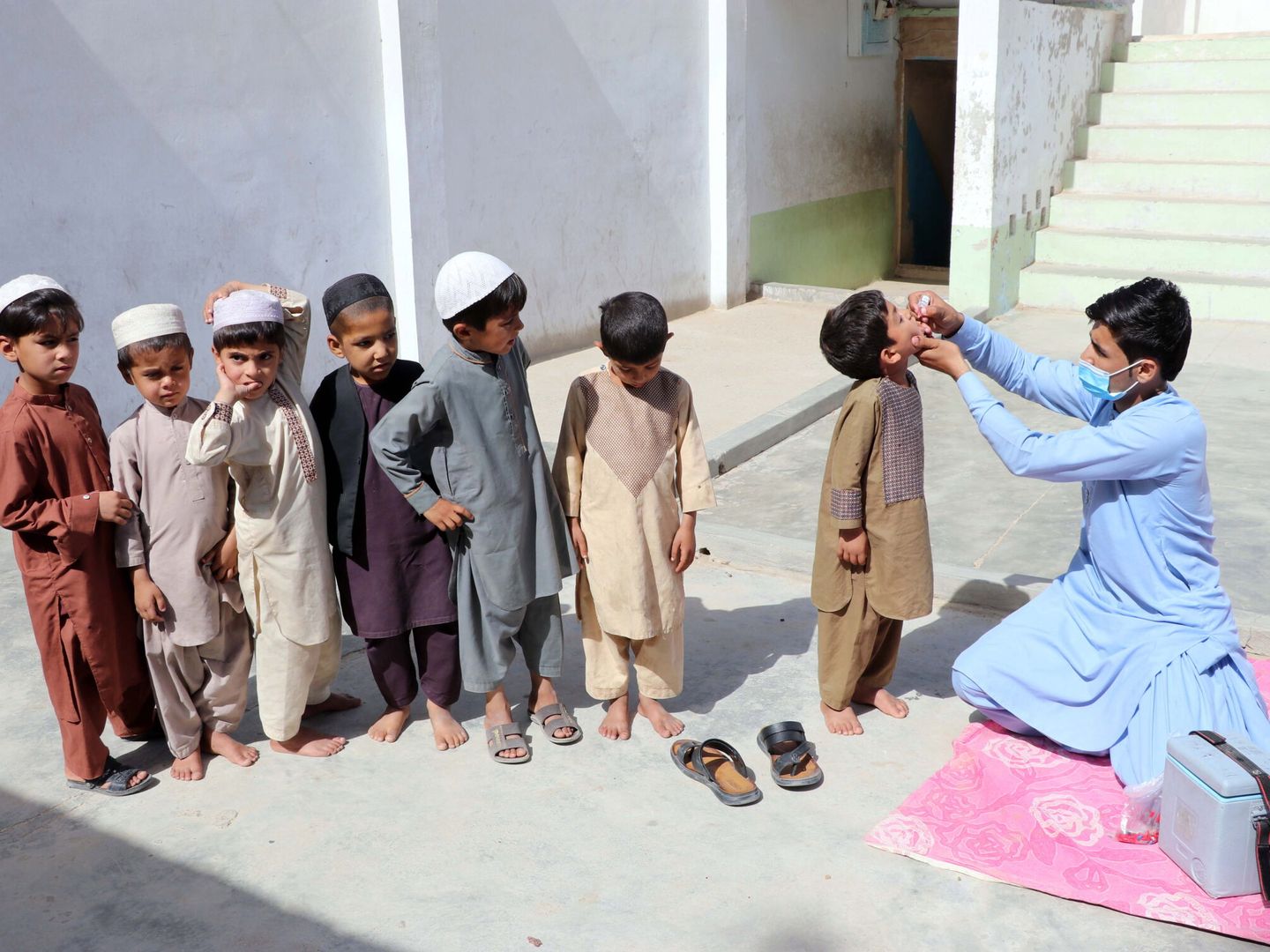Un trabajador sanitario administra vacunas contra la polio a niños en Afganistán, mayo de 2022. (EFE)