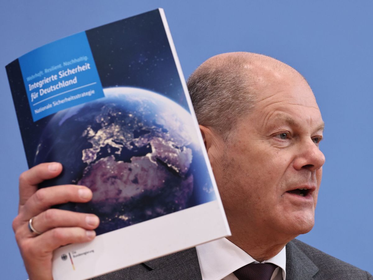 Foto: El canciller alemán, Olaf Scholz, sostiene un ejemplar de la estrategia de seguridad nacional. (EFE/Clemens Bilan)