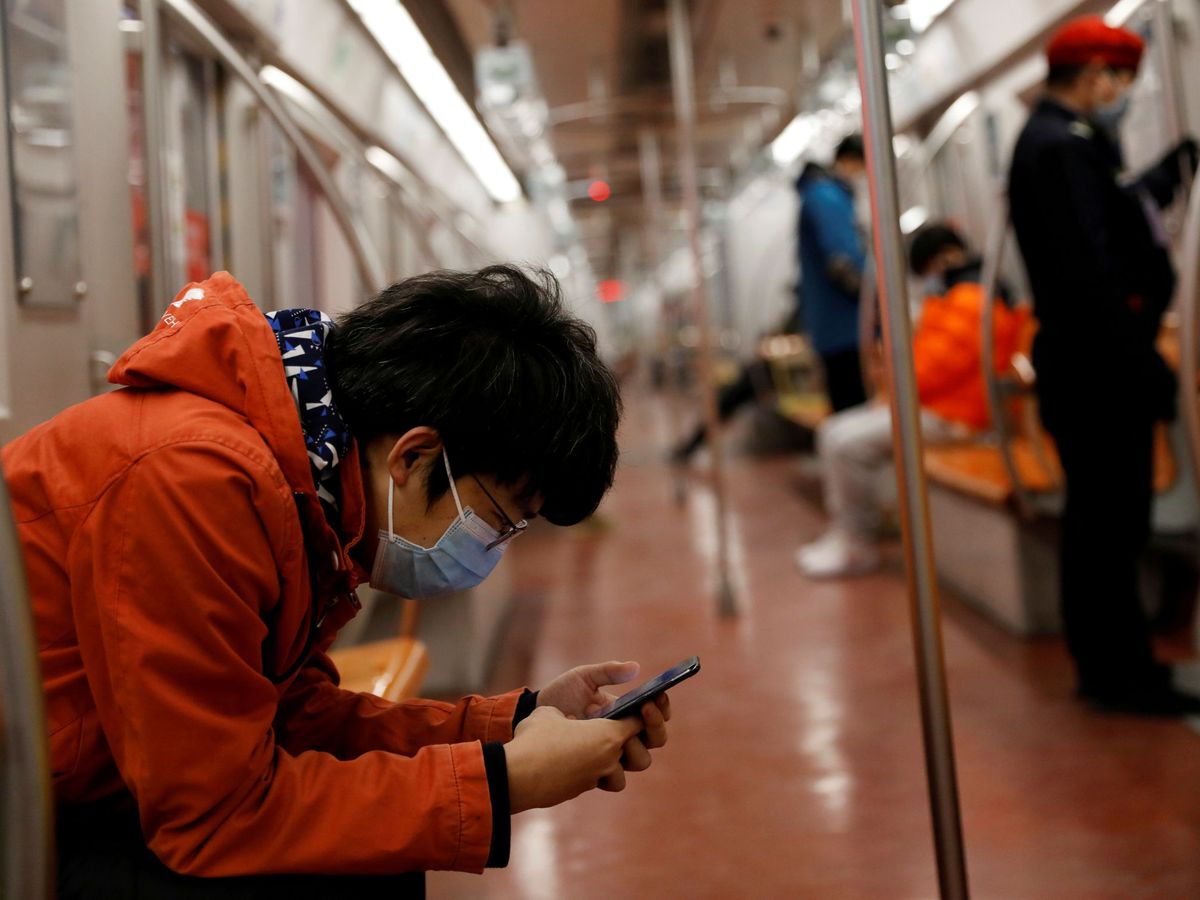 Foto: Un hombre mira su móvil en el metro de Pekín. (Reuters)