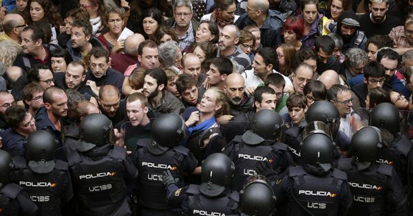 Foto: Agentes antidisturbios de la Policía Nacional forman un cordón de seguridad en los alrededores del colegio Ramón Llull de Barcelona el 1-O. (EFE) 