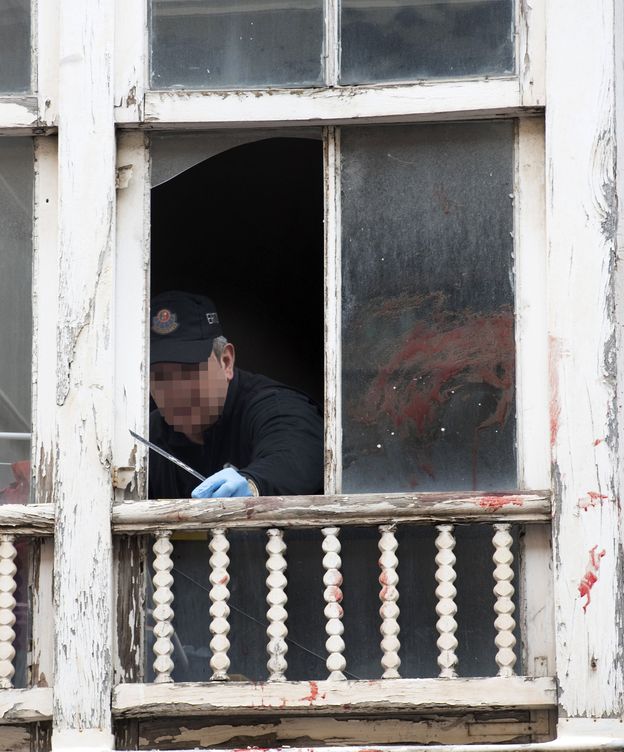 Foto: Un ertzaina toma pruebas en la ventana del domicilio. (EFE)