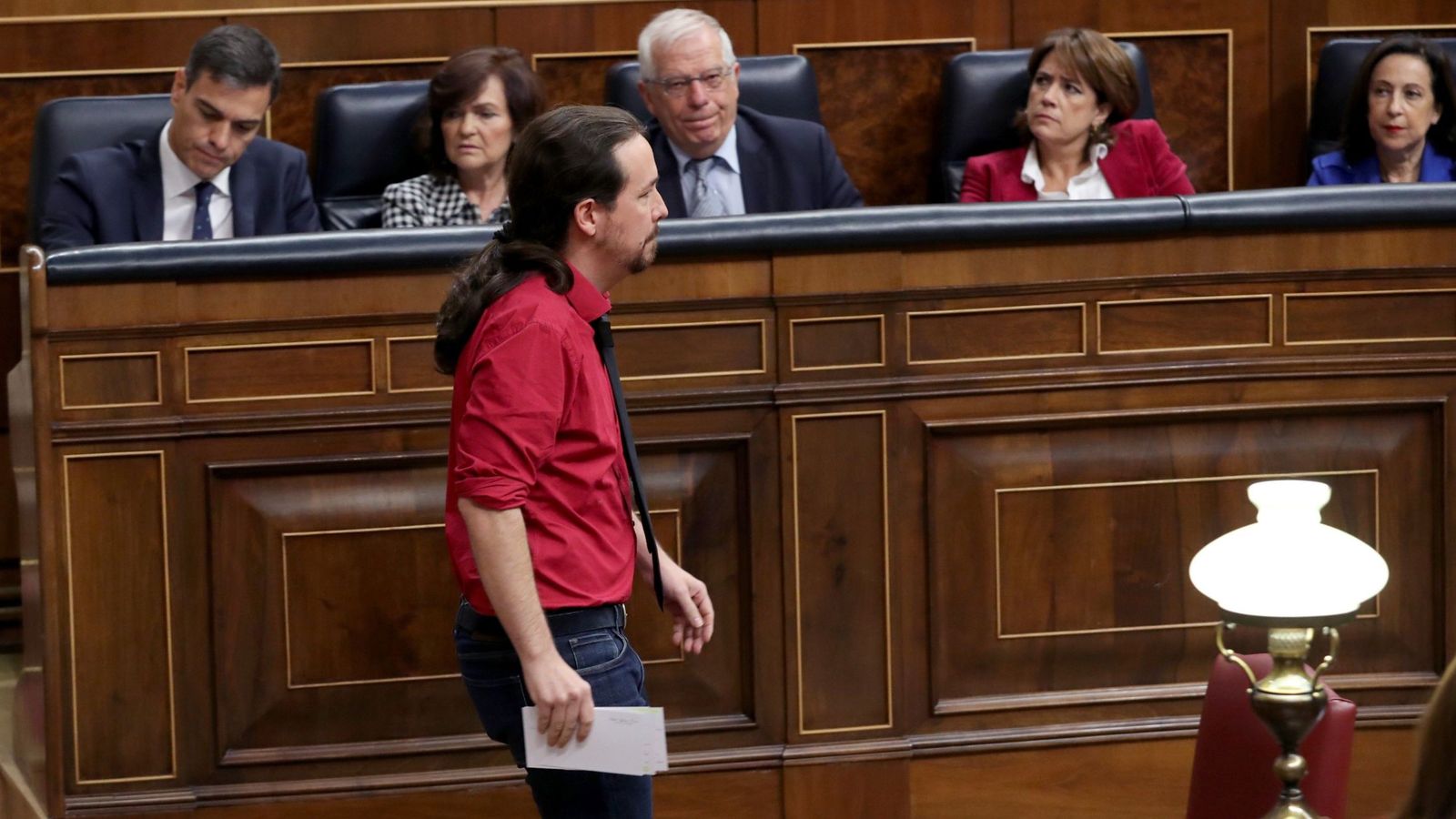 Foto: Pablo Iglesias pasa por delante de los miembros del Gobierno tras su intervención en el pleno del Congreso de este 24 de octubre. (EFE)