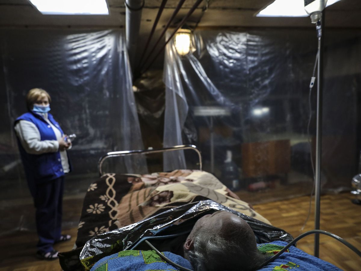 Foto: Una enfermera atiende a un hombre en un refugio. (EFE/EPA/Miguel A. Lopes)