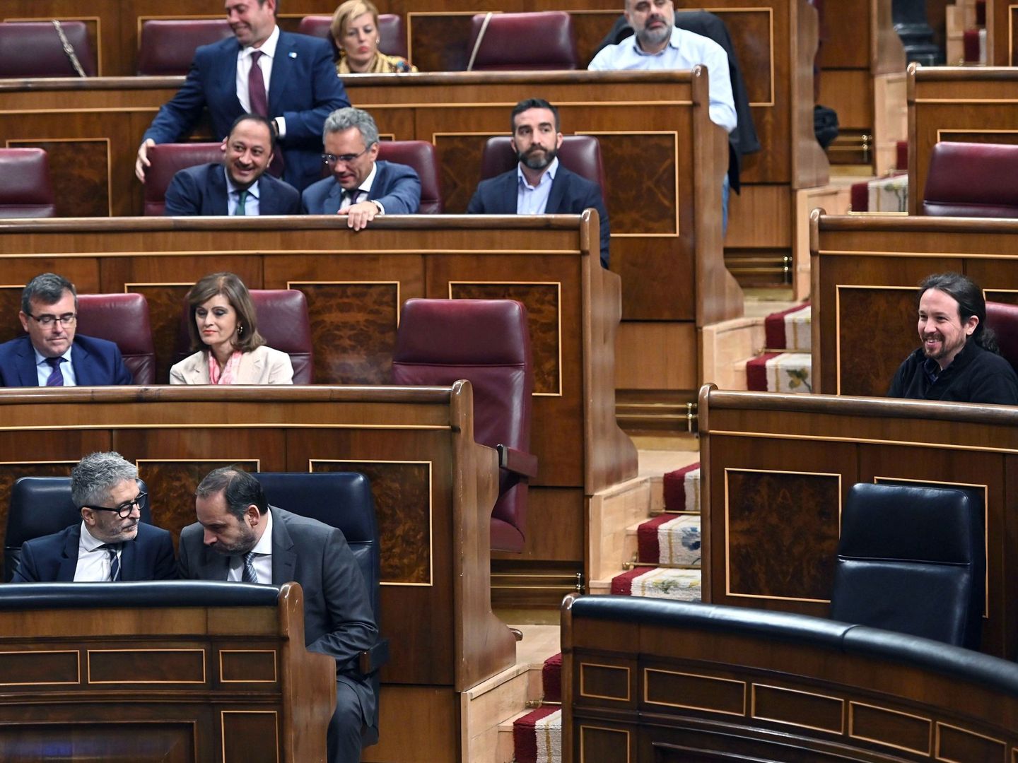 Los ministros José Luis Ábalos y Fernando Grande-Marlaska conversan con un Pablo Iglesias sentado en su escaño, este 10 de septiembre en el Congreso. (EFE)
