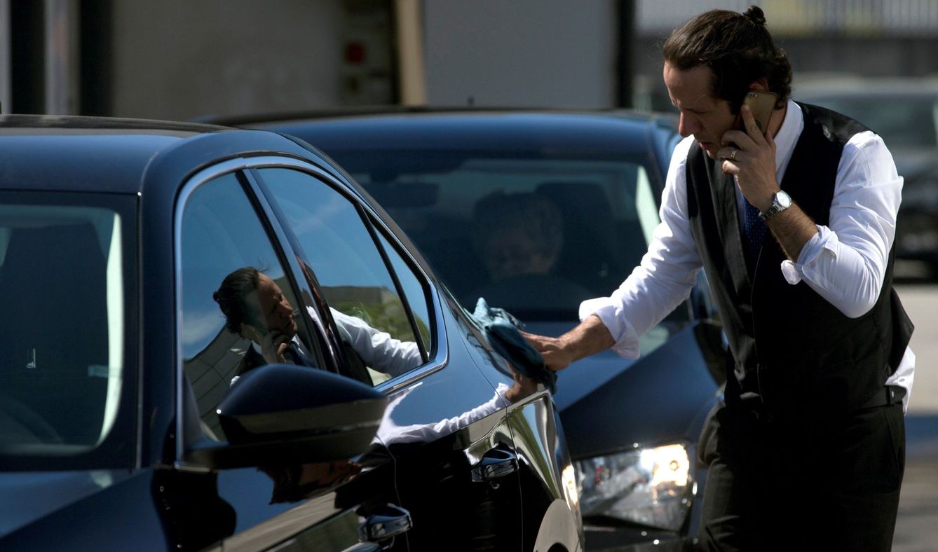 Un conductor de Cabify limpia su vehículo en Barcelona. (EFE)