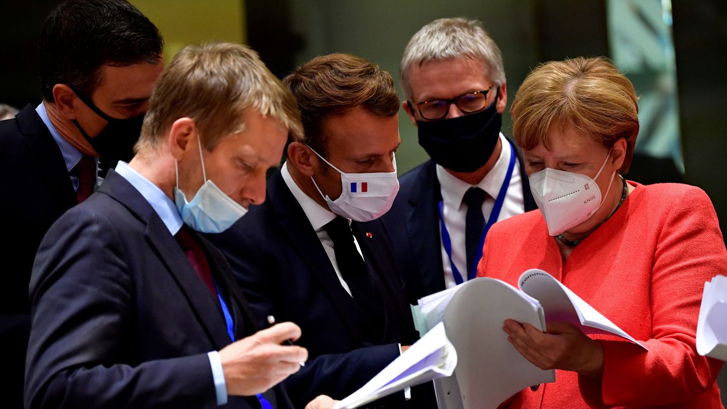 Los líderes revisan la documentación europea. Macron y Merkel lucen bandera. (Reuters)