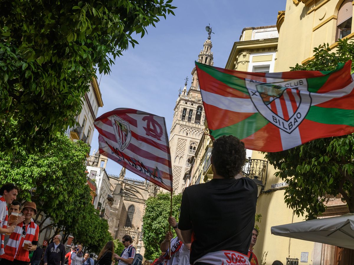 Foto: Aficionados del Athletic ondean banderas del equipo en Sevilla. (EFE/Raúl Caro)