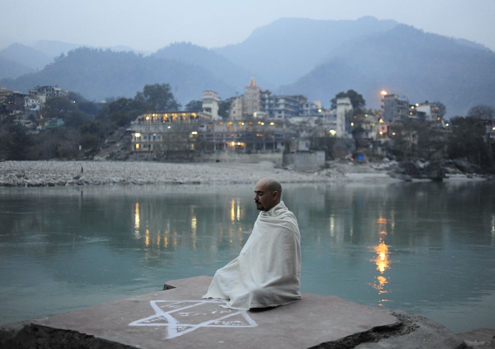 Foto: Alfredo Rey meditando con su ashram detrás en la ciudad de Risikesh. (Alfredo Rey)