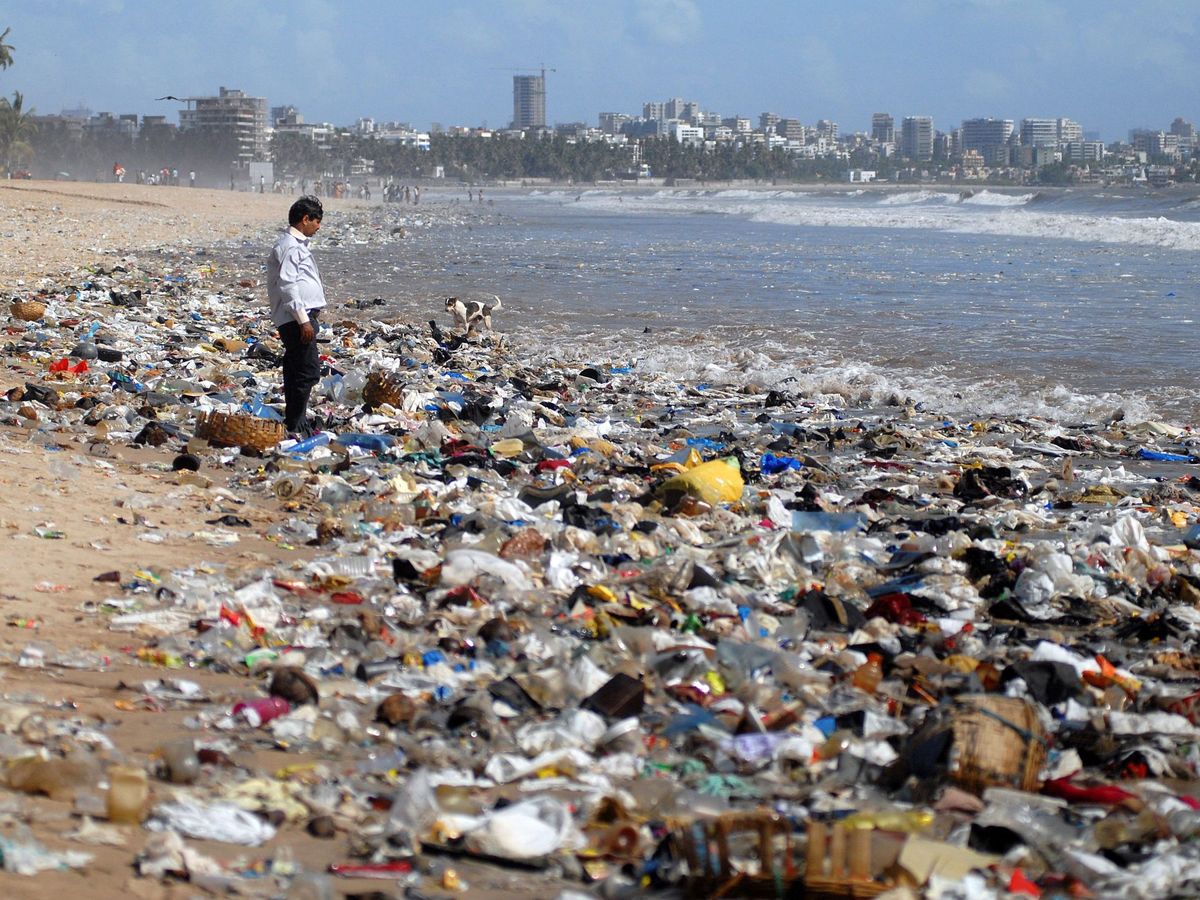 Foto: Un hombre observa una montaña de residuos plásticos a orillas del Mar Arábigo en Bombay, India. (EFE/Divyakant Solanji)